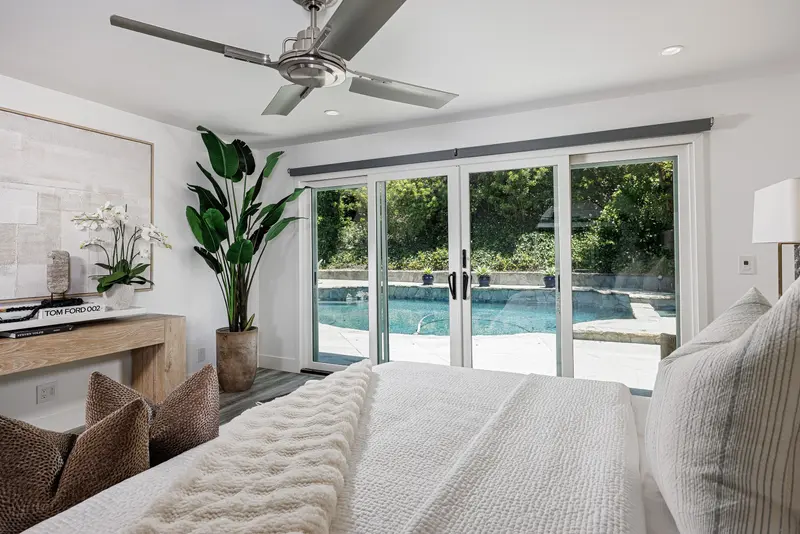 Primary bedroom with pool view through sliding doors — Corona del Mar real estate photography