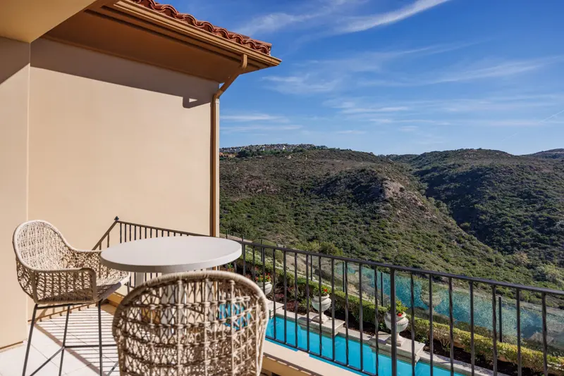 Balcony view over the pool toward the canyon hillside — Newport Coast real estate photography