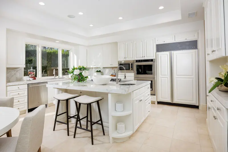 Kitchen with marble island and paneled built-in refrigerator — Newport Coast real estate photography